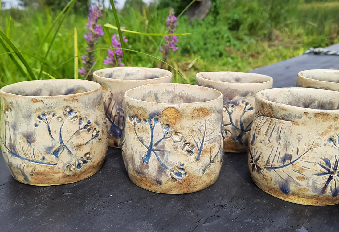 Zestaw zdobionych kubków ceramicznych w ogrodzie