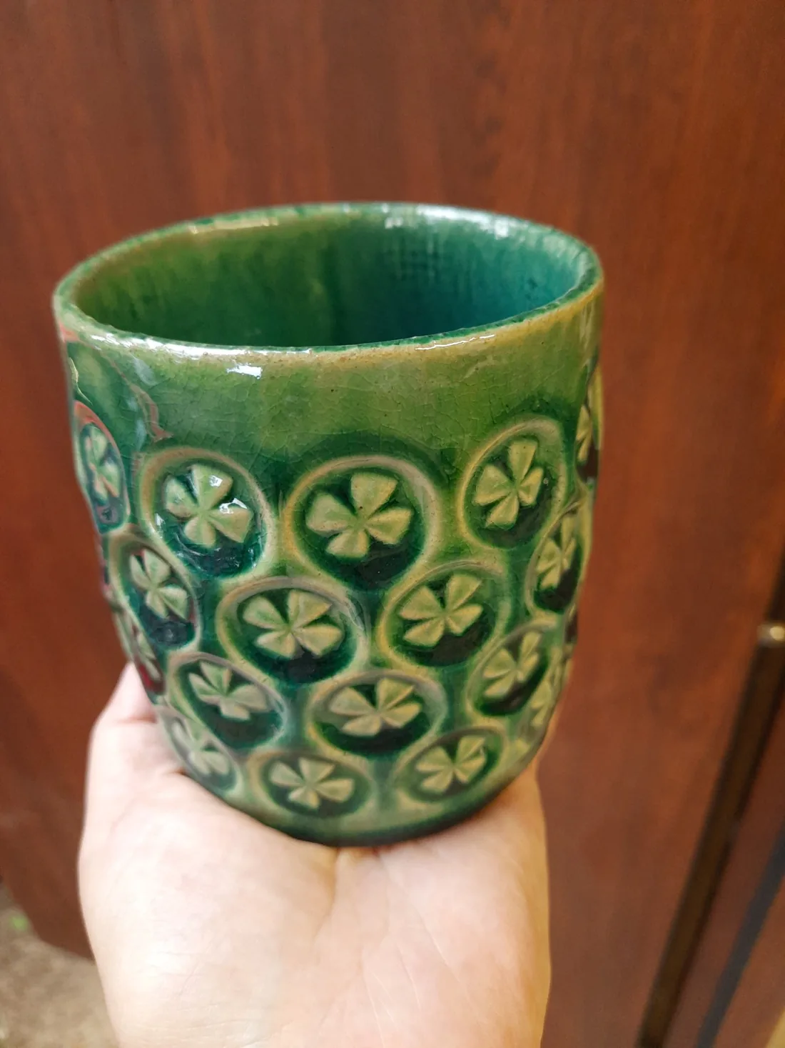 Zielony kubek ceramiczny z powtarzalnym wzorem czterolistnych rozet