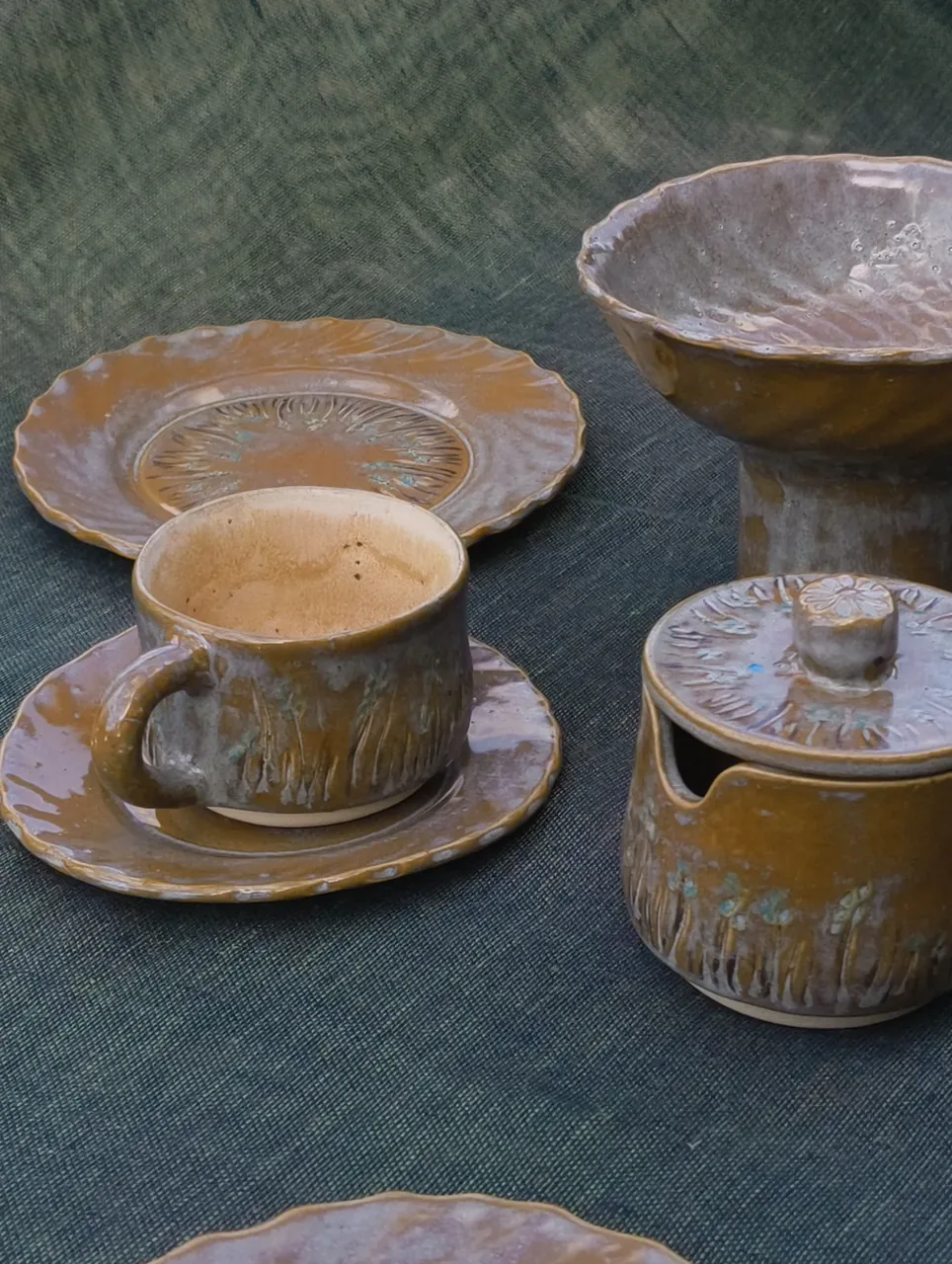 Niebieski ceramiczny talerz z czerwono-pomarańczowym wnętrzem i ciemny kubek w plenerze